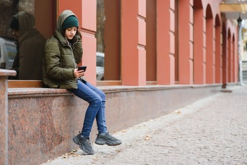 stylish teen girl outdoors in a hat and jacket