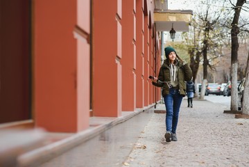 Obraz na płótnie Canvas young stylish beautiful teen girl listening to music, mobile phone, headphones, enjoying, denim outfit, smiling, happy, cool accessories, having fun, laughing, park