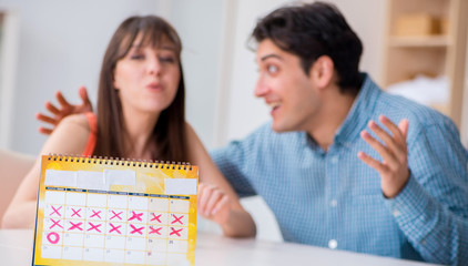 Young family in pregnancy planning concept with ovulation calend