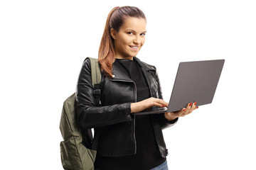 Female student holding a laptop and smiling at the camera