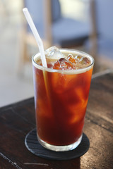 Iced americano coffee with ice on table in cafe.