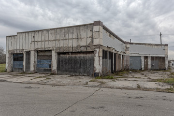 Long abandoned storefront with boarded up windows and doorways on cloudy day