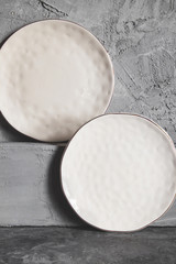 Gray empty plates (ceramic) on a gray stone background. Gray minimalism concept