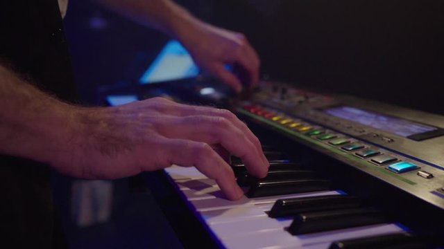 Close up man play synthesizer in club on rock stage