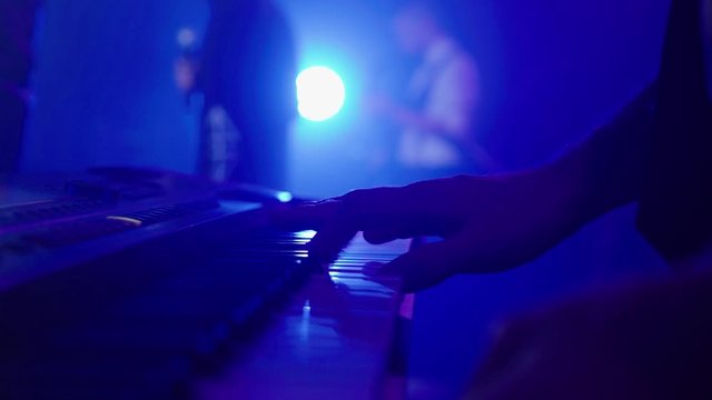 Close up man play synthesizer in club on rock stage