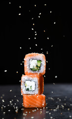 Japanese and Asian cuisine sushi set rolls with fresh ingredients over black - 306800253