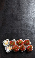 Japanese and Asian cuisine sushi set rolls with fresh ingredients over black