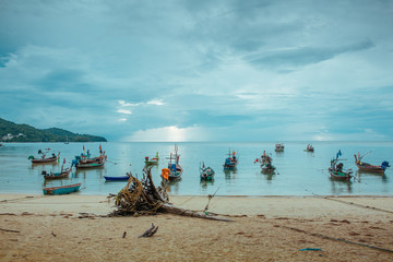 Fototapeta na wymiar Fishing boats on the beach in Asian tropical sea