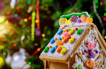 Fototapeta na wymiar Gingerbread house with decoration on christmas tree lights.