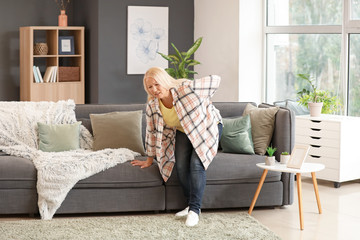 Mature woman suffering from back pain at home