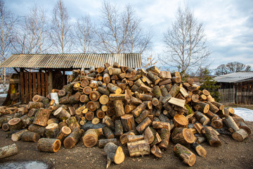 Russian village. Chopped firewood stacked in one big pile for kindling and heating the Russian hut in the winter season.