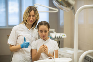Portrait of child girl patient and woman dentist in dental room.