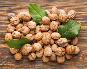 Many tasty walnuts on wooden background