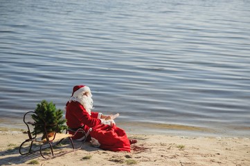 Santa Claus in swimming suit walking along the beach