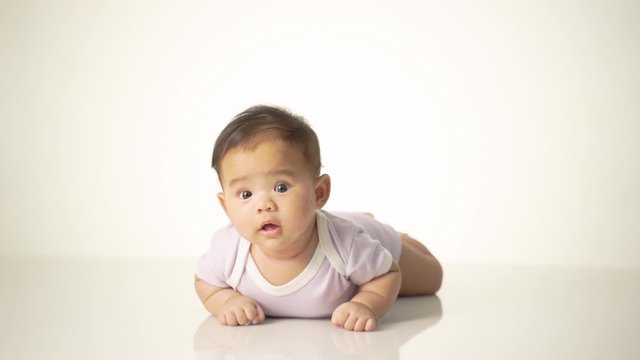 baby laying on her belly. tummy time cute baby in studio portrait