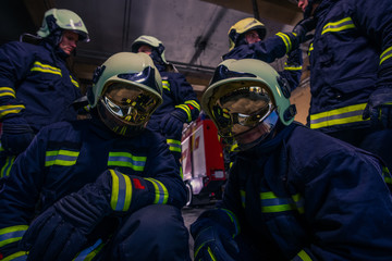 Portrait of group of firefighters wearing protective uniform inside the fire station