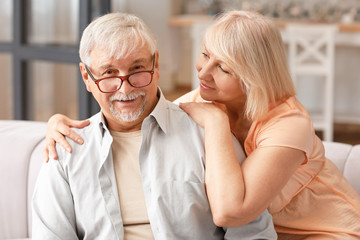 Happy mature couple resting together at home