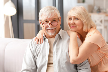 Happy mature couple resting together at home