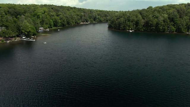 Aerial tracking shot of lake in cottage country Muskoka region