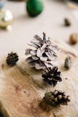 Rustic handmade table decor details in natural and white tones. Dining place decorated with pine cones