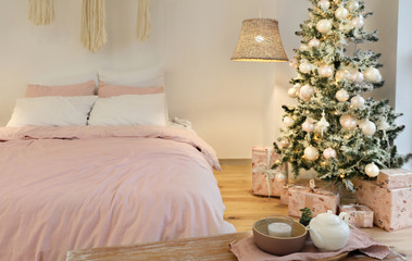 Stylish interior of bedroom with beautiful Christmas tree