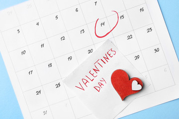 Calendar with marked date of Valentine's Day on color background