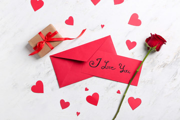 Envelopes, gift for Valentine's Day and rose on light background