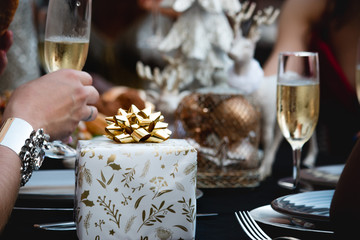 glass of Champagne in restaurant with Christmas gift on the table xmas party