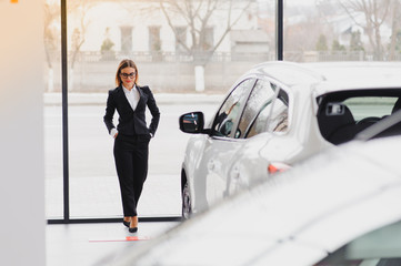 business woman in auto salon. concept of female driver