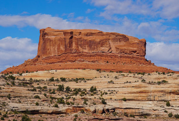 A beautiful and colorful sandstone bluff mountain guards the road to Canyonlands National Park.