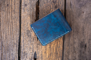 Leather navy blue with white cream wallet handmade working on wood background