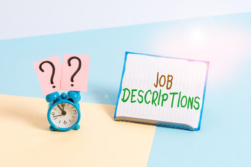 Conceptual hand writing showing Job Descriptions. Concept meaning a formal account of an employee s is responsibilities Alarm clock beside a Paper sheet placed on pastel backdrop