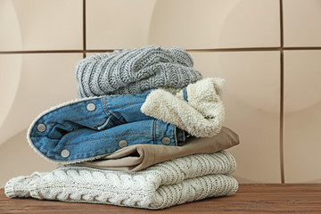 Set of warm winter clothes on table