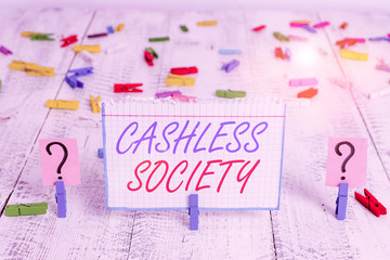 Conceptual hand writing showing Cashless Society. Concept meaning financial transactions are executed in electronic format Crumbling sheet with paper clips placed on the wooden table