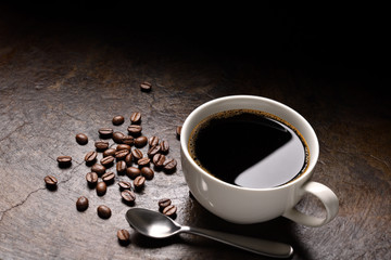 Cup of coffee and coffee beans on rustic background