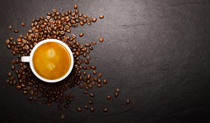 Cup of coffee and coffee beans on black background