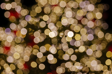 Gold and red Christmas light shiny abstract round bokeh on black background. Colourful Glitter bokeh from blurry decoration bulbs.