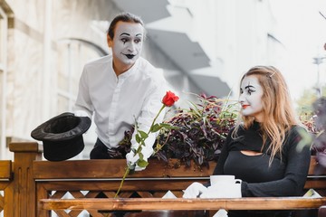 Mimes in front of Paris cafe acting like drinking tea or coffee.