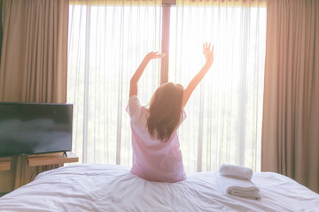 Beautiful woman waking up in her bed in the bedroom.