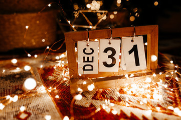 loose-leaf calendar with the date of December 31 in a garland and yellow bokeh close-up, the last...