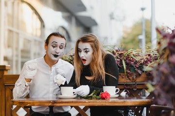 Mimes in front of Paris cafe acting like drinking tea or coffee.