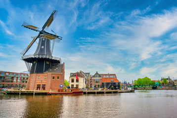 Fototapeta na wymiar A windmill along the canals in Haarlem, Netherlands on a clear day.