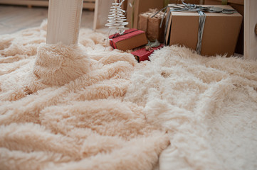 cozy fluffy plaid pastel shades on the background of gift boxes