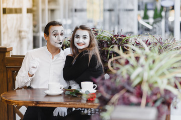 Mimes in front of Paris cafe acting like drinking tea or coffee.