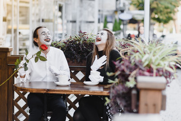 Mimes in front of Paris cafe acting like drinking tea or coffee.