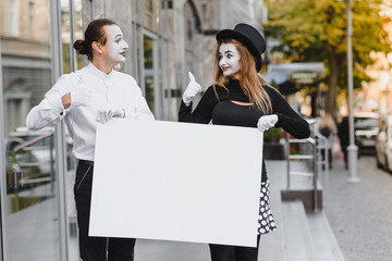 couple funny mimes holding sign