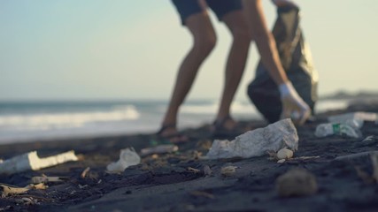 Young man clean up the beach from a trash