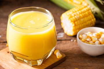 Fresh sweet corn juice (corn milk) and corn on wood background