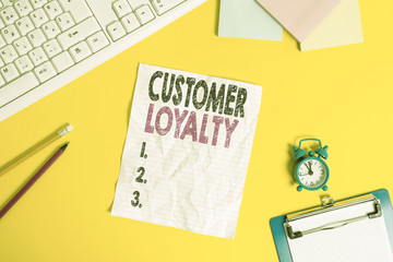 Text sign showing Customer Loyalty. Business photo text customers are devoted to a company s is products or services Copy space on notebook above yellow background with keyboard on table