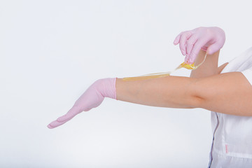Hands in rubber gloves close-up. doctor puts wax, honey. medic is preparing for depilation. Concept of medicine, medical instruments, health care, beauty industry, hair removal, natural material